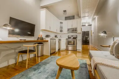 a living room with a kitchen with a couch and a table at Franklin Guesthouse in Brooklyn