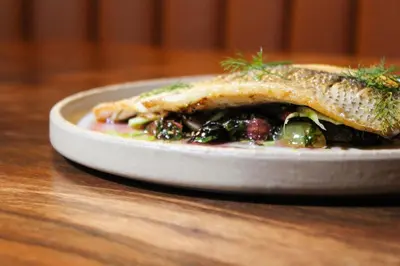 a plate of food with a fish on a table at Franklin Guesthouse in Brooklyn