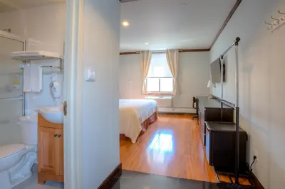 a bedroom with a bed and a sink and a toilet at LIC Hotel in Queens