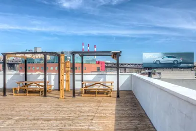 a patio with two tables and a car on a roof at LIC Hotel in Queens