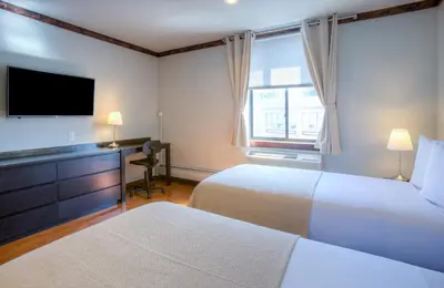 a hotel room with two beds and a flat screen tv at LIC Hotel in Queens