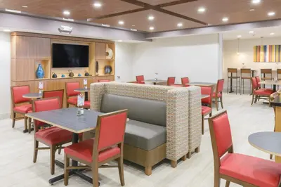 a restaurant with tables and chairs and a tv at Holiday Inn Express Southington by IHG in Southington