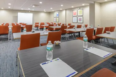 a conference room with tables and chairs and water bottles on a table at Holiday Inn Express Southington by IHG in Southington