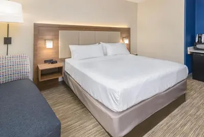 a bedroom with a large white bed and a couch at Holiday Inn Express Southington by IHG in Southington