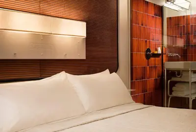 a bedroom with a bed and a wall with a mirror at The Standard, High Line New York in New York