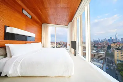 a bedroom with a large bed and a large window at The Standard, High Line New York in New York