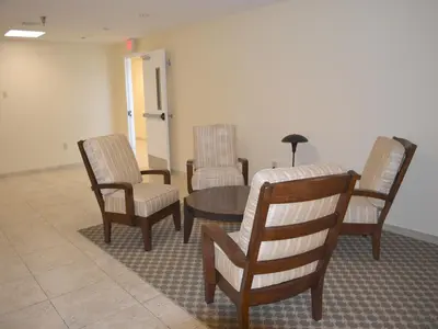 a waiting room with three chairs and a table at Baymont by Wyndham East Windsor Bradley Airport in East Windsor