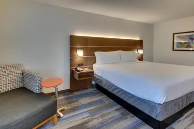 a hotel room with a bed and a chair at Holiday Inn Express Fishkill-Mid Hudson Valley by IHG in Fishkill