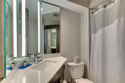 a bathroom with a sink and a toilet and a mirror at Holiday Inn Express Fishkill-Mid Hudson Valley by IHG in Fishkill