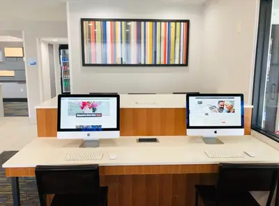 two computer monitors sitting on a desk in a office at Holiday Inn Express Fishkill-Mid Hudson Valley by IHG in Fishkill