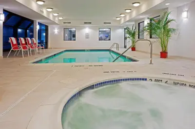 a pool in the middle of a room with chairs and a table at Holiday Inn Express Fishkill-Mid Hudson Valley by IHG in Fishkill