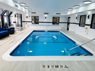 a swimming pool in a building with blue water at Holiday Inn Express Fishkill-Mid Hudson Valley by IHG in Fishkill