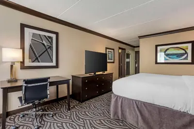 a hotel room with a bed and a desk and a tv at Best Western Plus Kingston Hotel and Conference Center in Kingston