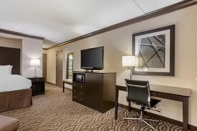 a hotel room with a bed and a desk and a tv at Best Western Plus Kingston Hotel and Conference Center in Kingston