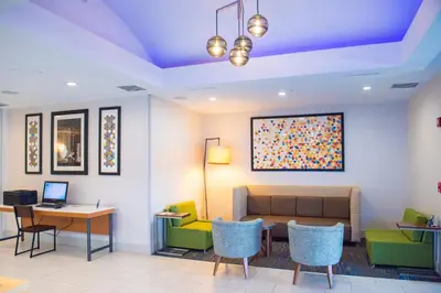 a waiting room with a couch and a table and chairs at Holiday Inn Express Hotel & Suites Chester by IHG in Chester