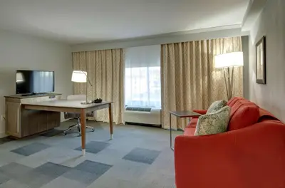 a hotel room with a desk and a red chair at Hampton Inn & Suites Springfield Downtown in Springfield