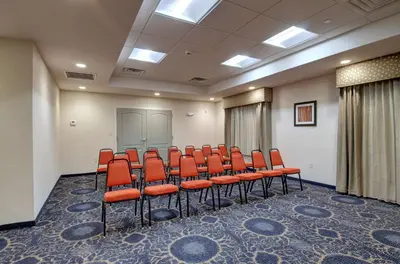 a conference room with orange chairs in front of a screen at Hampton Inn & Suites Springfield Downtown in Springfield