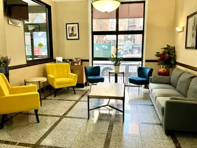 a waiting room with couches and chairs and a table at Heritage Hotel New York City in New York