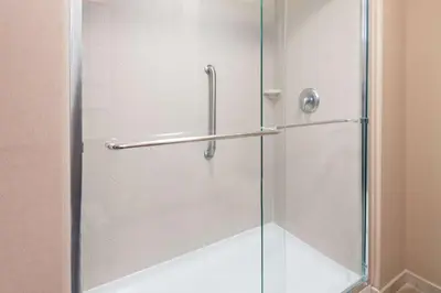 a shower stall with a glass shower door at Hampton Inn Springfield South Enfield in Enfield