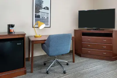 a room with a desk and a television and a chair at Hampton Inn Springfield South Enfield in Enfield