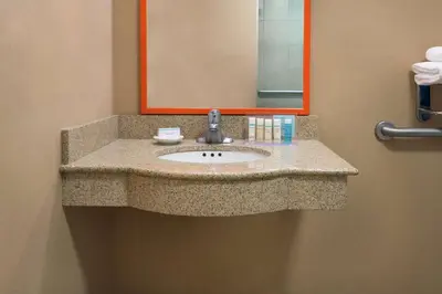 a bathroom counter with a sink and a mirror at Hampton Inn Springfield South Enfield in Enfield