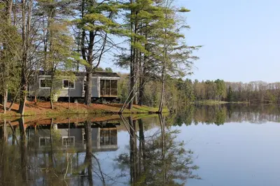 a house on an island in the middle of a lake at Alpine Lake Lakefront Park Model 4 in South Corinth