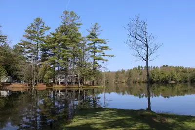 a house on the shore of a lake at Alpine Lake Lakefront Park Model 4 in South Corinth