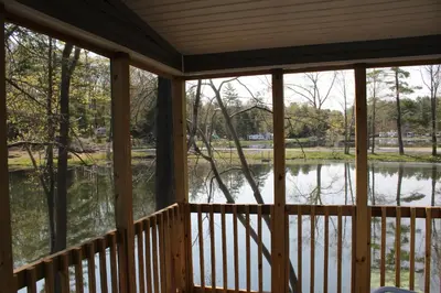 a screened in porch with a view of a lake at Alpine Lake Lakefront Park Model 4 in South Corinth