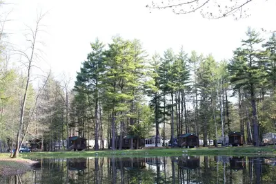 a campsite next to a lake with trees at Alpine Lake Lakefront Cabin 5 in South Corinth