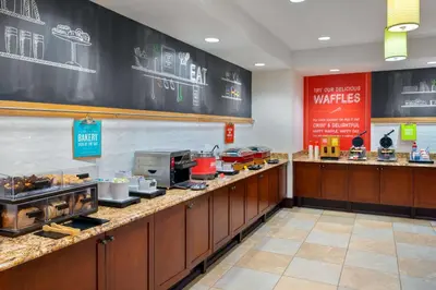 a restaurant with a counter with food on it at Hampton Inn and Suites Hartford/Farmington in Farmington