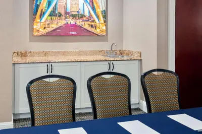 a kitchen with a counter with two chairs and a sink at Hampton Inn and Suites Hartford/Farmington in Farmington