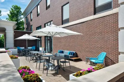 a patio with tables and chairs and umbrellas at Hampton Inn and Suites Hartford/Farmington in Farmington