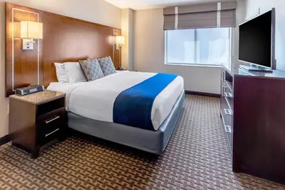 a hotel room with a bed and a flat screen tv at New Haven Hotel in New Haven