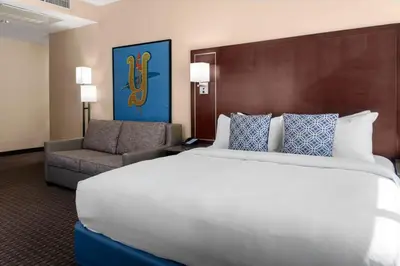 a hotel room with a large bed and a chair at New Haven Hotel in New Haven