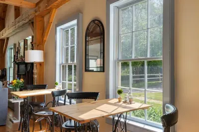 a restaurant with tables and chairs and windows at Inn at Silver Maple Farm in East Chatham