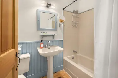 a bathroom with a sink and a toilet and a mirror at Inn at Silver Maple Farm in East Chatham