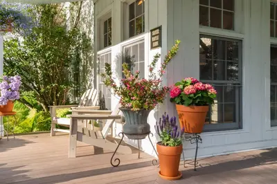 a porch with three pots of flowers on it at Inn at Silver Maple Farm in East Chatham