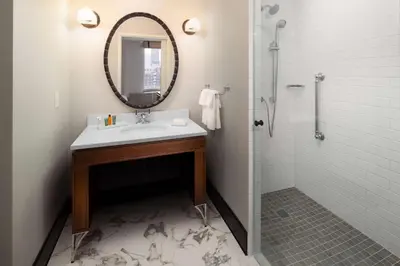 a bathroom with a sink and a mirror and a shower at Hilton Brooklyn New York - Newly Renovated in Brooklyn