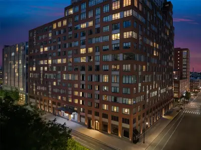 a tall building with many windows at night at Hilton Brooklyn New York - Newly Renovated in Brooklyn