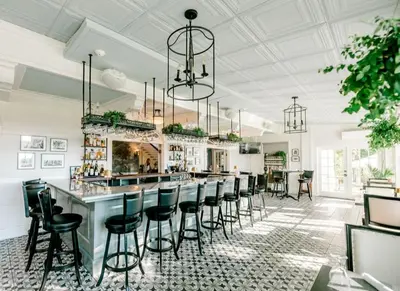 a bar with black bar stools in a restaurant at The White House Inn in Wilmington