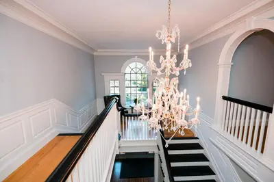 a staircase with a chandelier in a room at The White House Inn in Wilmington