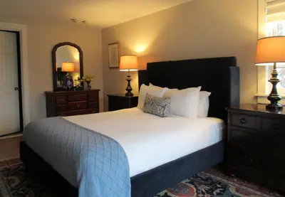 a bedroom with a large bed and a mirror at The White House Inn in Wilmington