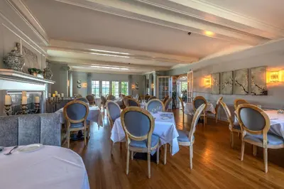 a restaurant with tables and chairs in a room at The White House Inn in Wilmington