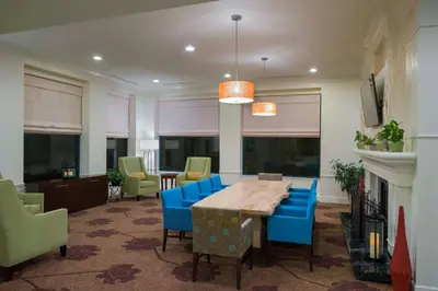 a dining room with a table and blue chairs at Hilton Garden Inn Hartford South/Glastonbury in Glastonbury