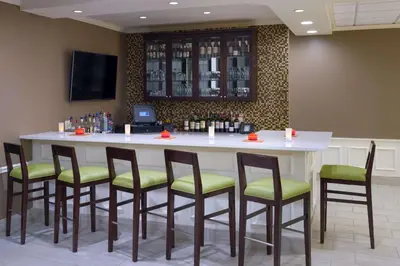 a bar in a restaurant with chairs around it at Hilton Garden Inn Hartford South/Glastonbury in Glastonbury