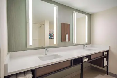 a bathroom with two sinks and a large mirror at Hilton Garden Inn Danbury in Danbury