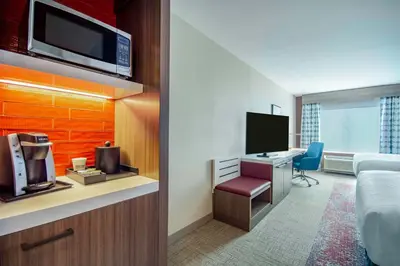 a hotel room with a bed and a desk with a tv at Hilton Garden Inn Danbury in Danbury