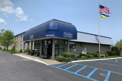 a building with an american flag in front of it at Travelodge Inn & Suites by Wyndham Albany in Albany