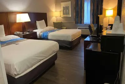 a hotel room with two beds and a television at Travelodge Inn & Suites by Wyndham Albany in Albany