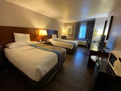 a hotel room with two beds and a television at Travelodge Inn & Suites by Wyndham Albany in Albany